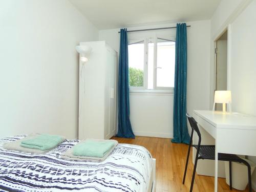 une chambre avec un lit, un bureau et une fenêtre dans l'établissement LM86 , CENTRE VILLE , BALCON , AU CALme, à Lorient