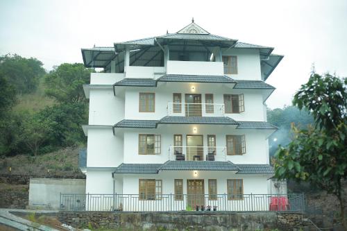 una casa blanca con techo en una colina en Moody Moon Vagamon, en Vagamon