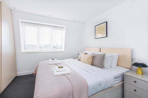 a bedroom with a bed with two towels on it at Harley Street Luxury Apartments by City Relay in London