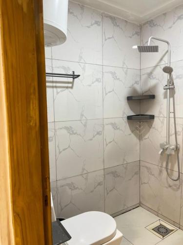 a bathroom with a toilet and a glass shower at Comfort et style au coeur de la ville in Lomé