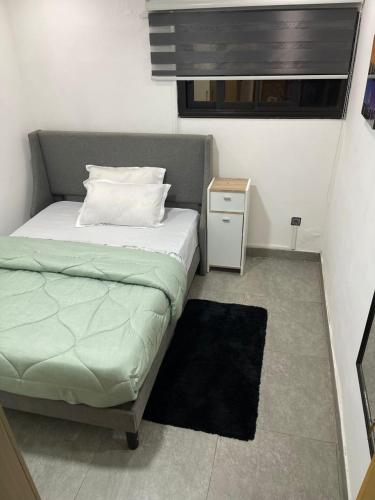 a small bedroom with a bed and a night stand at Comfort et style au coeur de la ville in Lomé