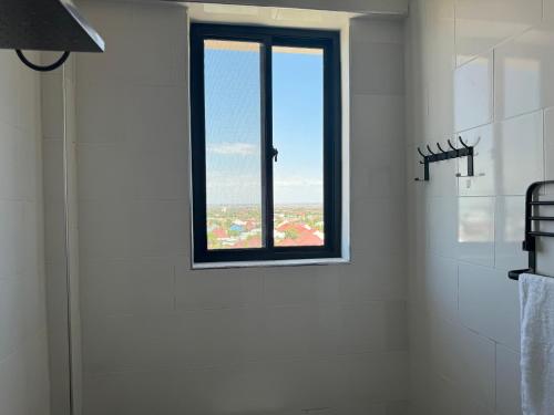 a window in a white bathroom with a shower at Eastern City Apartments in Dodoma