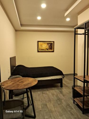 a room with a bed and a table in it at La morada Enamorada in Mexico City