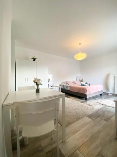 une chambre avec une table blanche et un lit dans l'établissement Studio Clara - proche gare et aéroport, balcon, à Village-Neuf
