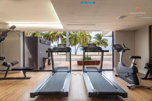 a gym with treadmills and elliptical machines at Unity - Duplo em Cabo Branco por Carpediem in Penha