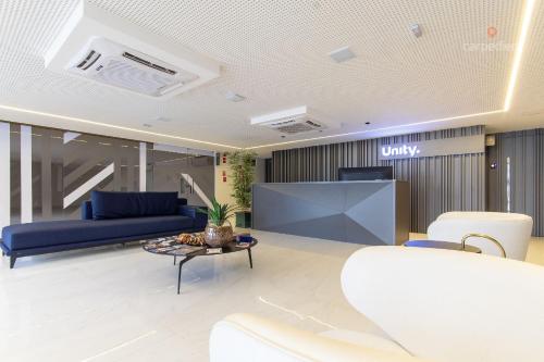a lobby with a blue couch and a table at Unity - Duplo em Cabo Branco por Carpediem in Penha