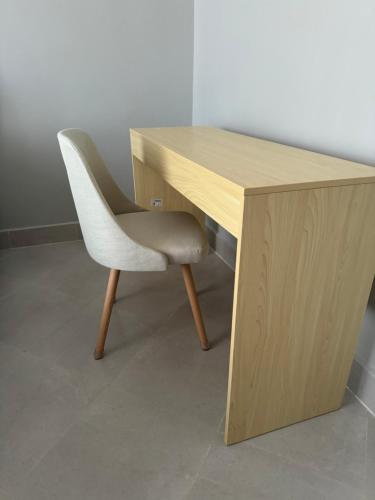 a wooden desk with a white chair sitting next to it at Eastern City Apartments in Dodoma