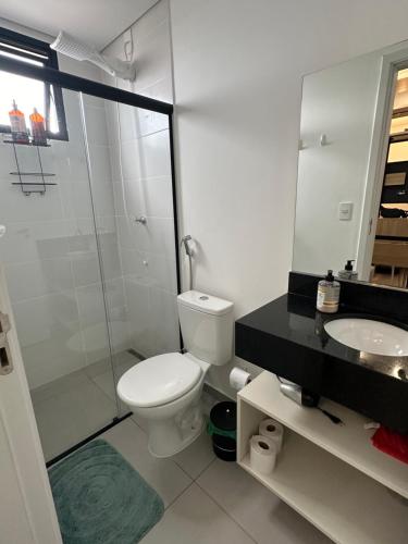 a white bathroom with a toilet and a sink at APTO TESLA 02,com piscina e Ar condicionado in São Carlos