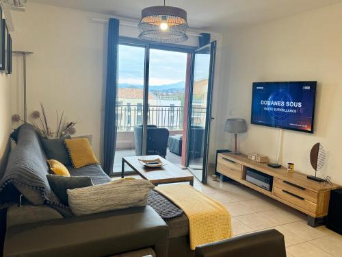 un salon avec un canapé et une télévision dans l'établissement Appartement Aix en Provence - la Duranne Piscine Parking Privé Dernier Etage, à Aix-en-Provence