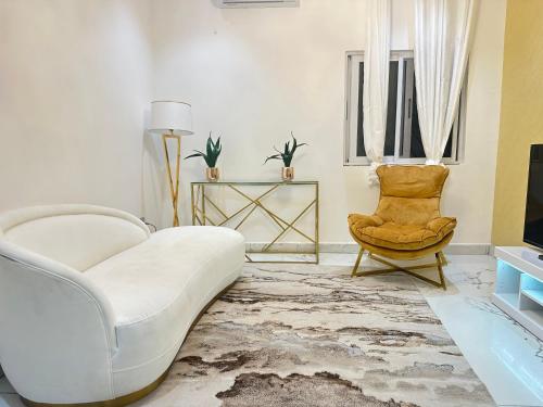 a living room with a white couch and a chair at Vittins 2 in Tantra Hill