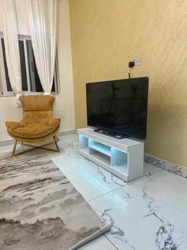 a living room with a flat screen tv and a chair at Vittins 2 in Tantra Hill