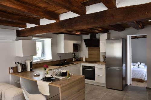 une cuisine avec des armoires blanches et des appareils en acier inoxydable dans l'établissement La Pommeraie - Balnéo- Queen Size- Canal- Parking, à Chécy