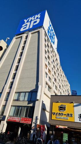 a building with a sign on the top of it at 新大阪徒步30秒 Shinosaka Station 30s, Direct to Kansai Airport 關西空港直達, Universal Studio 16 mins, Umeda 6 mins, Kyoto 25 mins, Early Check in in Osaka