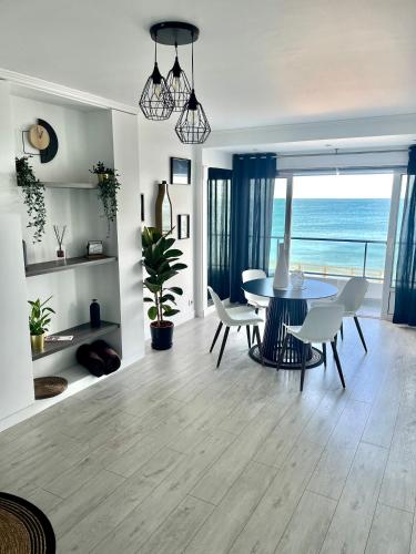 une salle à manger avec une table et des chaises et l'océan dans l'établissement Le Pic D'Etretat, à Étretat