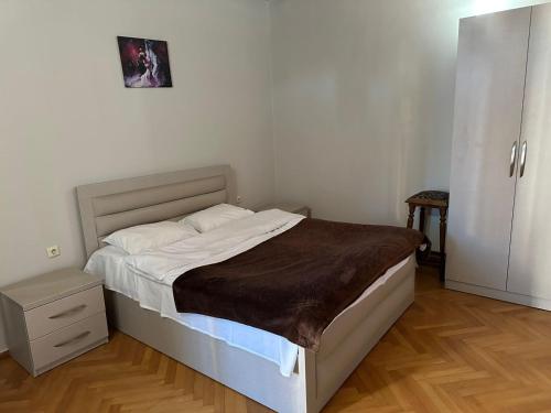 a bedroom with a large bed with a wooden floor at Hotel Cattaleya in Batumi