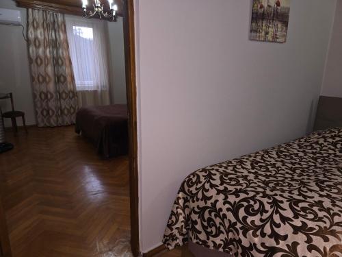 a bedroom with a mirror next to a bed at Hotel Cattaleya in Batumi