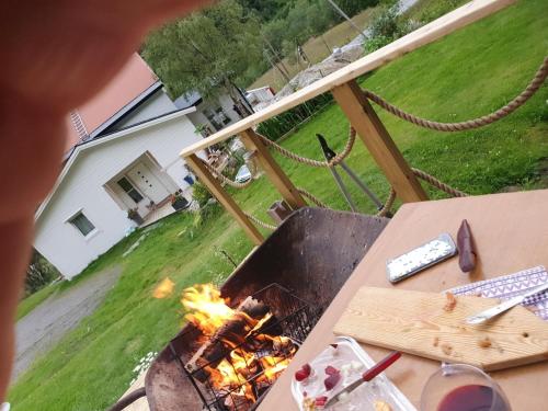 a grill with fire in a backyard with a house at Modern house in Lavangen