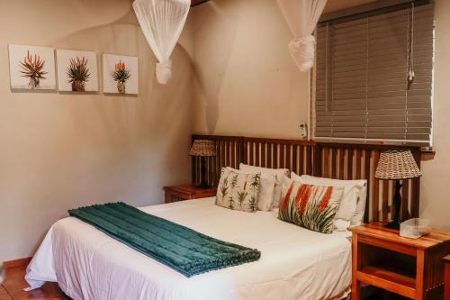 a bedroom with a bed with white sheets and a window at A Traveller's Palm in Phalaborwa