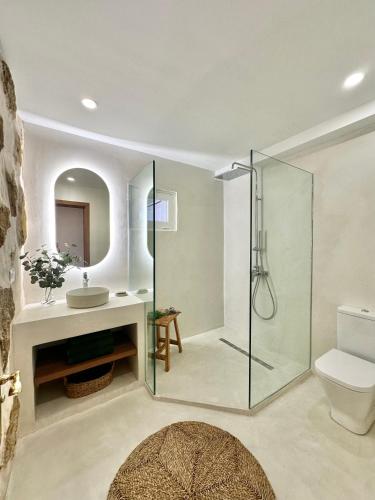 a bathroom with a glass shower and a toilet at Finca El Pedregal - Suite Olivo in Haría
