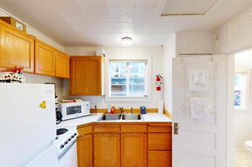a kitchen with a sink and a white refrigerator at Baerfoot Bungalow in Cannon Beach