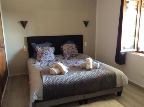 une chambre avec un lit avec deux animaux en peluche dessus dans l'établissement Maison A Tigliola, à Porto-Vecchio