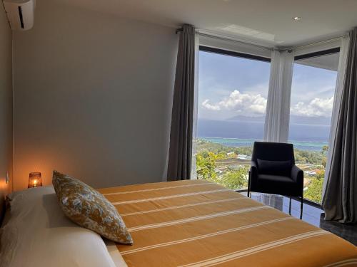 a bedroom with a bed with a view of the ocean at TAHITI - Villa Green M in Punaauia