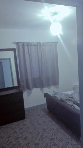 a bedroom with a ceiling fan and a bed and a window at D'Chin Dorcelle Suite in Norbury