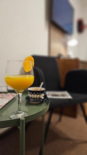 a glass of orange juice sitting on a table at Hotel Protea Bolesławiec in Bolesławiec