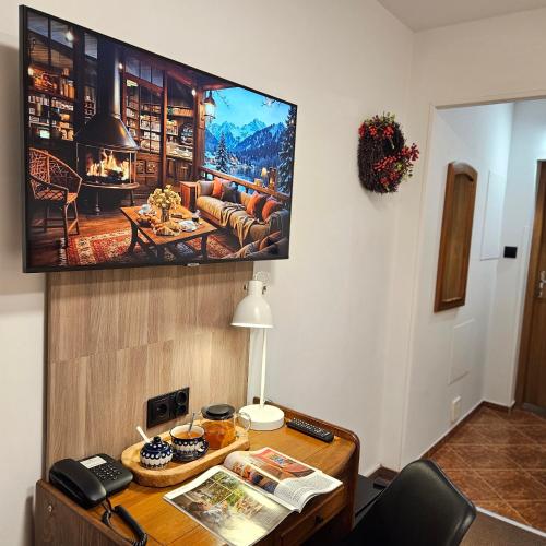 a living room with a tv hanging on the wall at Hotel Protea Bolesławiec in Bolesławiec