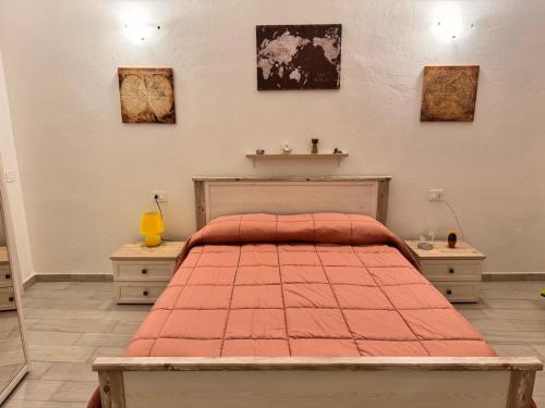 a bedroom with a bed with a red comforter at Stanza Globo in Nulvi