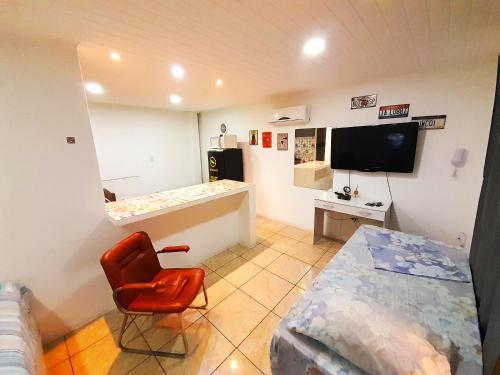 a room with a bedroom with a bed and a desk at JK POUSADA FLATS EXECUTIVE GARAGEM central in Pelotas