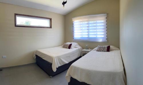 a bedroom with two beds and a window at Antu relajo y natura in Curacautín