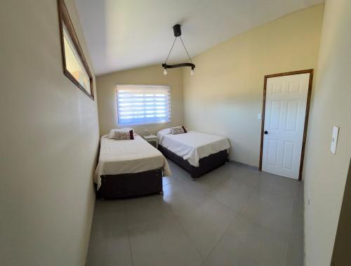 a room with two beds and a window at Antu relajo y natura in Curacautín