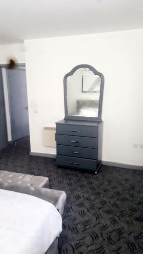 a bedroom with a mirror and a dresser with a bed at D'Chin Dorcelle Suite in Norbury
