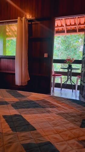 a room with a table and a large window at Floresta Zen - Pousada Xamanica in Manaus