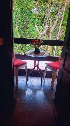 a table and two chairs and a table with flowers on it at Floresta Zen - Pousada Xamanica in Manaus