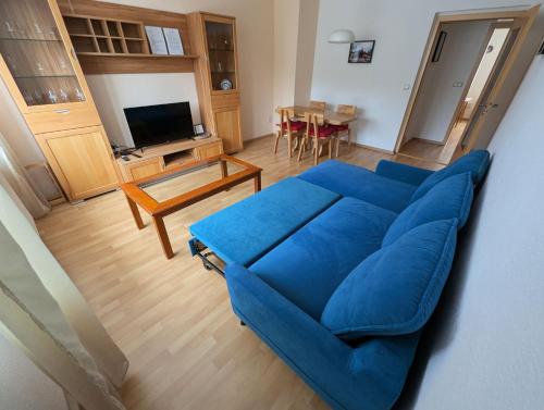 a living room with a blue couch and a table at FeWo Lotti - 5 Personen, ruhige Lage, WLAN in Kurort Oberwiesenthal
