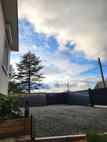 une maison avec une clôture et un arbre en arrière-plan dans l'établissement La Bodéga, à Arnage