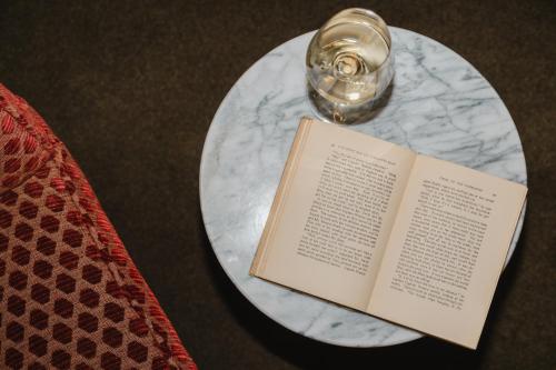 a book on a table next to a glass at The Belvedere Hotel - Kingston in Kingston