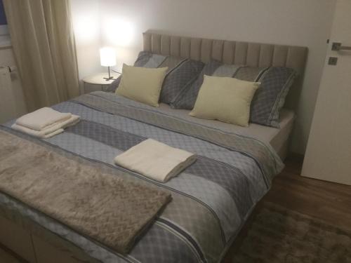 a large bed with two pillows and two towels on it at A2 Apartman in Sopron