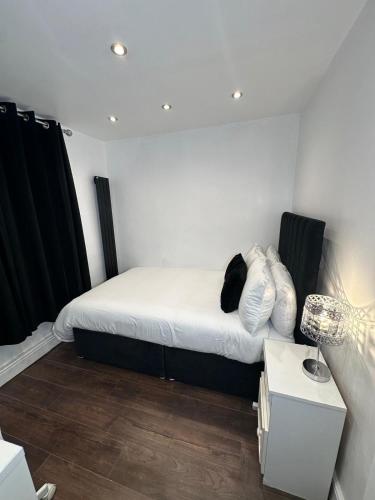 a bedroom with a bed with white sheets and pillows at Two Bedrooms Bungalow Garden Lodge in Aveley