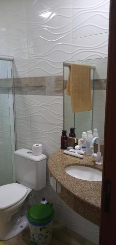 a bathroom with a toilet and a sink and a mirror at CHALÉ LUZIMAREs 01 in Ilhéus