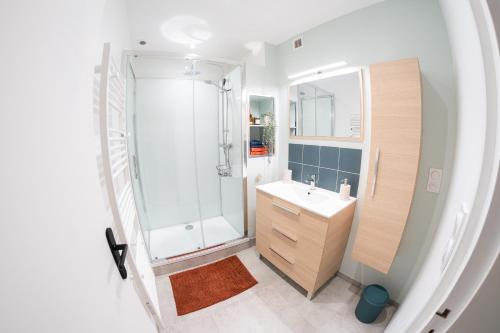 une salle de bain blanche avec une douche et un lavabo dans l'établissement Les Mouettes - Centre Ville - à 500m du Port, à Granville