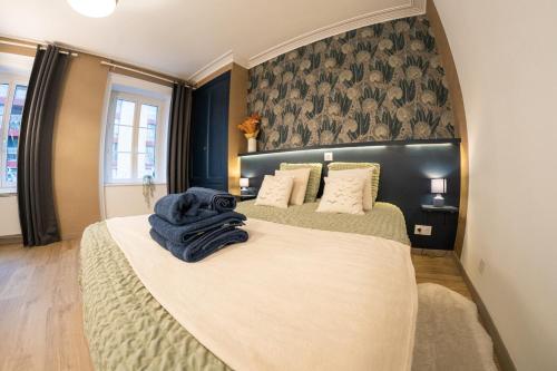 - une chambre avec 2 lits et une couverture bleue sur le lit dans l'établissement Les Mouettes - Centre Ville - à 500m du Port, à Granville