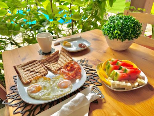 a table with a plate of eggs and bread and toast at La Curadiña - Encuentro Surf Resort in Cabarete