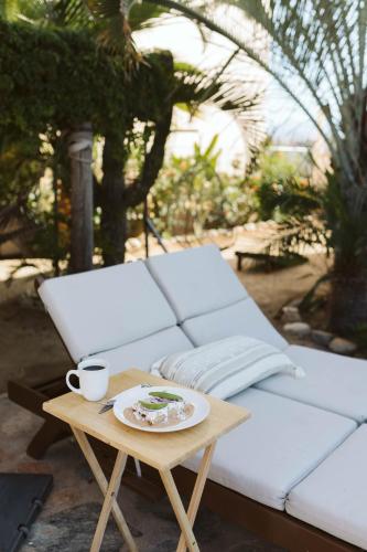 a table with a plate of food and a coffee cup at Olas de Cerritos in El Pescadero