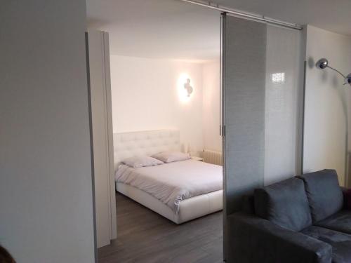 - une chambre avec un lit et une porte en verre avec un canapé dans l'établissement Le41Annecy T2 40m2 old town private parking, à Annecy