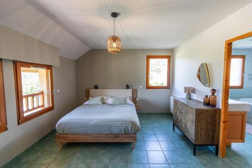 a bedroom with a bed and a dresser and a mirror at Les Roses du Vercors Maison Villard de Lans in Villard-de-Lans
