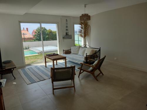un salon avec un canapé, une table et des chaises dans l'établissement villa récente 100m2, a 50mplage piscine privée clim parking, au Pradet