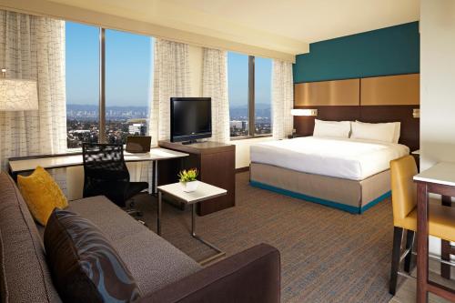 a hotel room with a bed and a couch at Residence Inn by Marriott Los Angeles LAX/Century Boulevard in Los Angeles